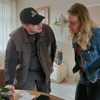 Medewerker Groninger Huis geeft bewoner uitleg over energiedisplay